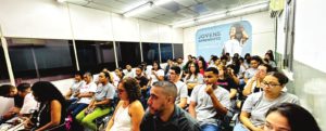 Jovens no auditório do CAMP Mangueira durante evento